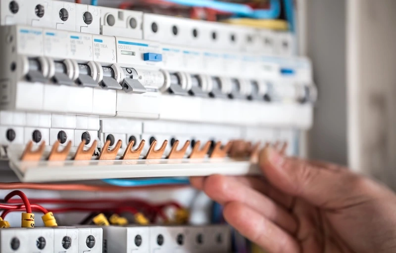 Tekniker installerar automatsäkringar i en elcentral